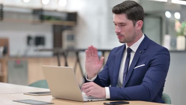 Glada affärsman talar på videosamtal på laptop i Office — Stockvideo