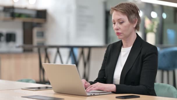 オフィスのノートパソコンでビデオ通話を行う古いビジネスマンの女性 — ストック動画
