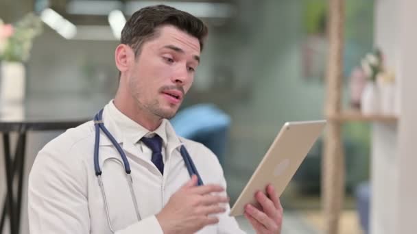 Videollamada por Young Male Doctor en Tablet — Vídeos de Stock
