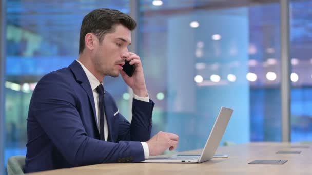 Uomo d'affari che parla al telefono al lavoro — Video Stock