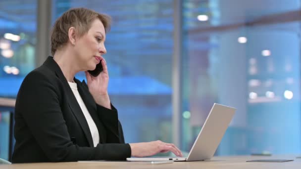 Telefonbeszélgetés idős üzletasszonnyal a munkahelyen — Stock videók
