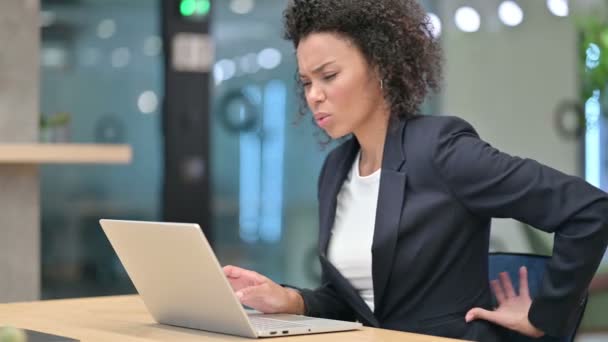 Zmęczony afrykański bizneswoman z laptopem mając ból pleców w pracy — Wideo stockowe