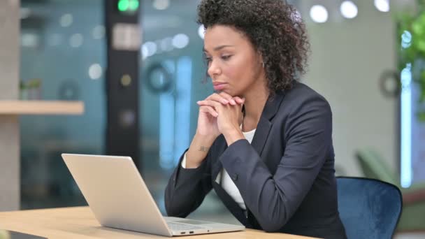 Pensive African Businesswoman Thinking while working on Laptop — стоковое видео