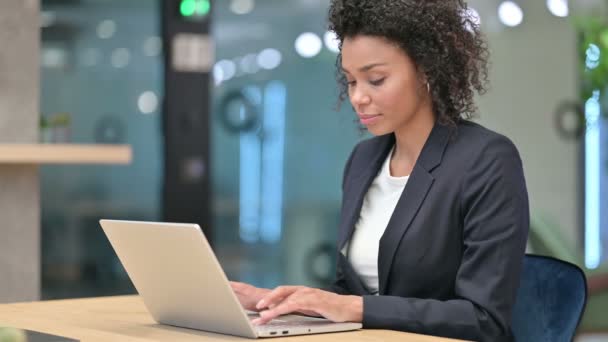 Empresaria africana emocionada por el éxito en el ordenador portátil en el trabajo — Vídeos de Stock