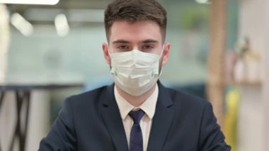 Koruyucu Yüz Maskeli Genç İş Adamı Başparmaklarını Gösteriyor 