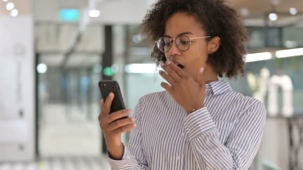 Mujer de negocios africana celebrando el éxito en Smartphone — Vídeos de Stock