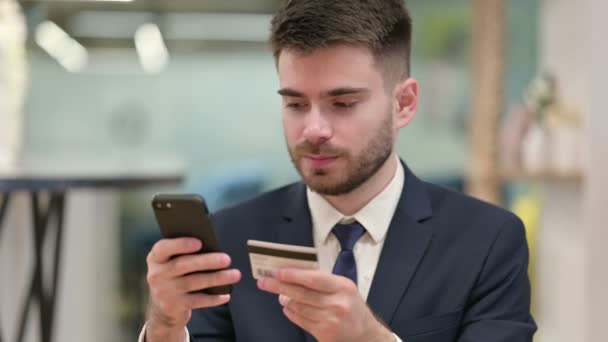 若いビジネスマンがスマートフォンでオンライン決済を行う — ストック動画