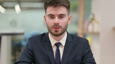 Kamerayı işaret eden iddialı genç iş adamı.