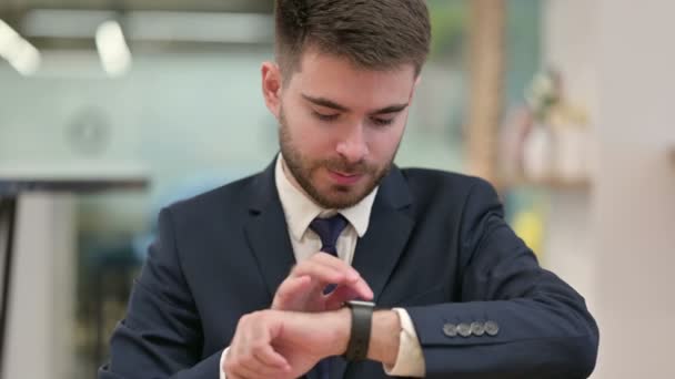 職場でスマートウォッチを使う若い実業家 — ストック動画
