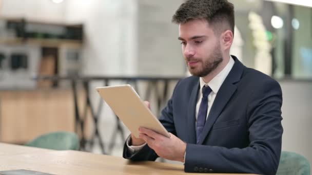 Молодой бизнесмен использует планшет в офисе — стоковое видео