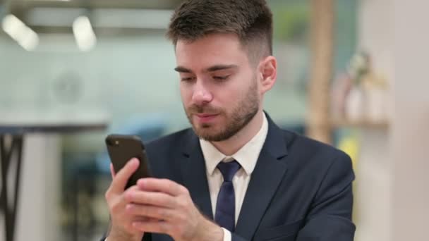 Verontruste jonge zakenman met verlies op Smartphone — Stockvideo