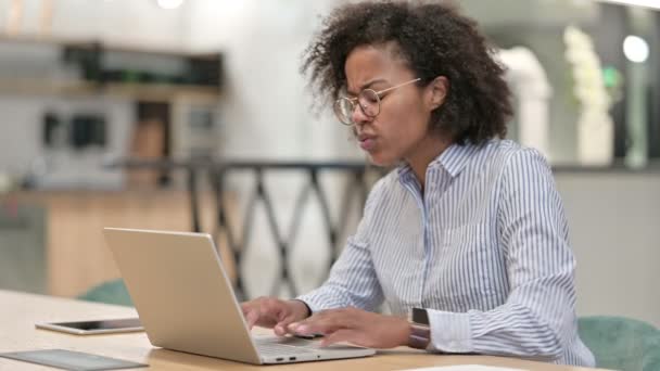 Obosită femeie de afaceri africană cu laptop având dureri de spate în birou — Videoclip de stoc