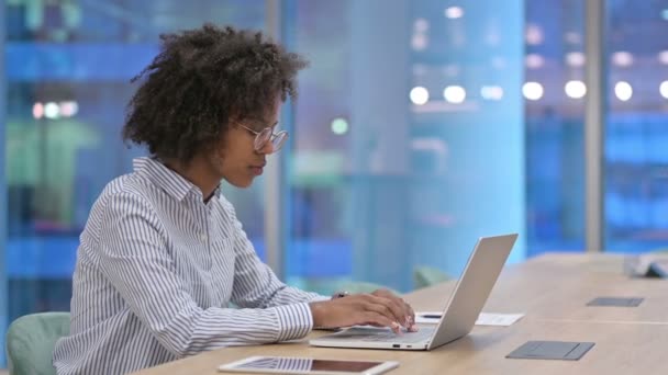 Empresaria africana enfocada trabajando en la computadora portátil en la oficina — Vídeos de Stock