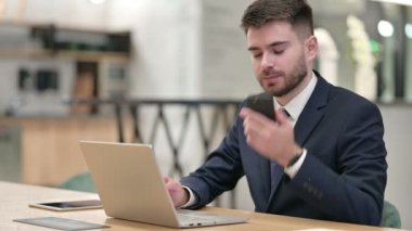 Bilgisayarlı Genç İş Adamı Ofiste Akıllı Telefonla Konuşuyor 