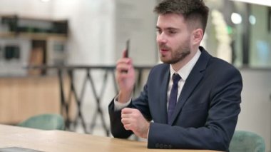 Neşeli Genç İş Adamı Ofiste Akıllı Telefonla Konuşuyor