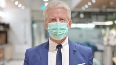 Yüzü Maskeli Kıdemli Yaşlı İş Adamının Portresi Başparmakları Gösteriyor 