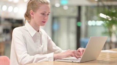 Dizüstü bilgisayarlı olumlu genç iş adamı