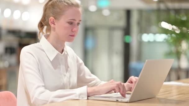 Sérieux jeune femme d'affaires avec ordinateur portable pointant vers la caméra — Video