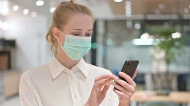 Smartphone kullanan Yüzü Maskeli Genç İş Kadını Portresi 