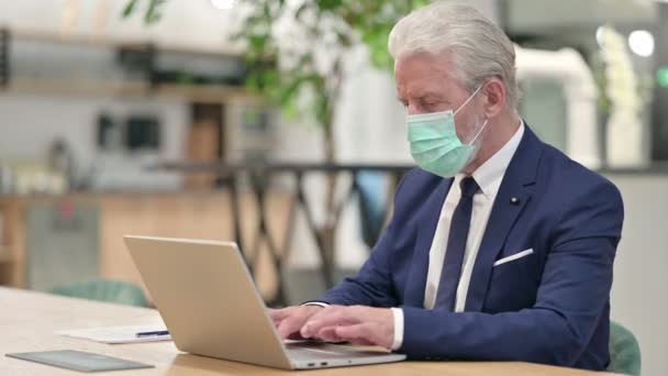 Vecchio uomo d'affari anziano con maschera facciale che lavora sul computer portatile — Video Stock