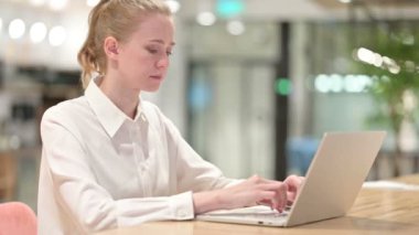 Dizüstü bilgisayarlı Ciddi Genç İş Kadını Kameraya Bakıyor 