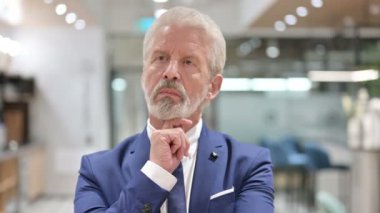 Düşünceli yaşlı iş adamının portresi.