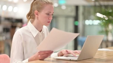 Laptop ve Evrak işlerinde çalışan güzel genç iş kadını.