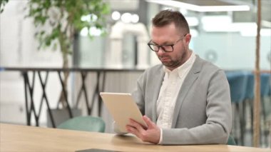 Ofiste Tablet kullanan sıradan genç adam 