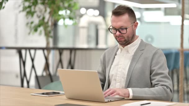 Nemocný ležérní mladý muž s laptopem kašel v kanceláři — Stock video