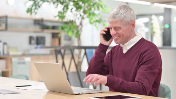 Moyen Age homme parlant au téléphone et travaillant sur ordinateur portable — Video