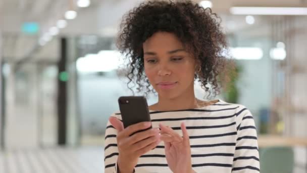 Retrato de una empresaria africana celebrando el éxito en Smartphone — Vídeos de Stock