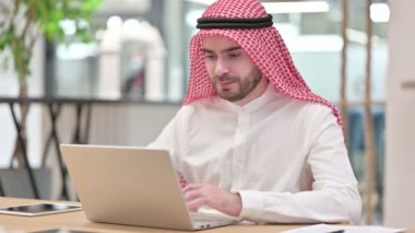 Ciddi bir Arap iş adamı dizüstü bilgisayarla 