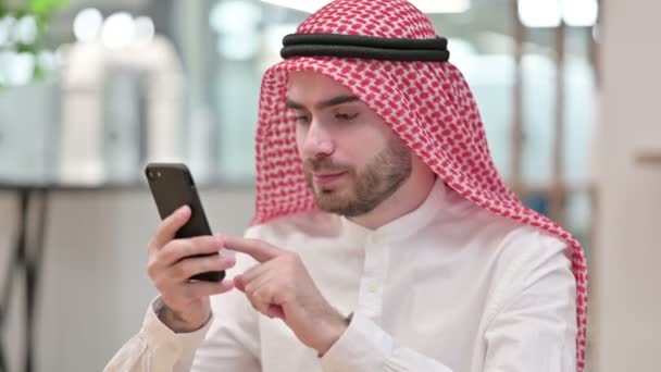 Arab Businessman świętuje sukces na smartfonie w biurze — Wideo stockowe