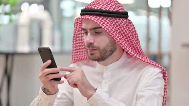 Zdenerwowany arabski biznesmen o straty na smartfonie w biurze — Wideo stockowe
