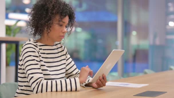 Seriöse junge afrikanische Geschäftsfrau nutzt Tablet im Büro — Stockvideo