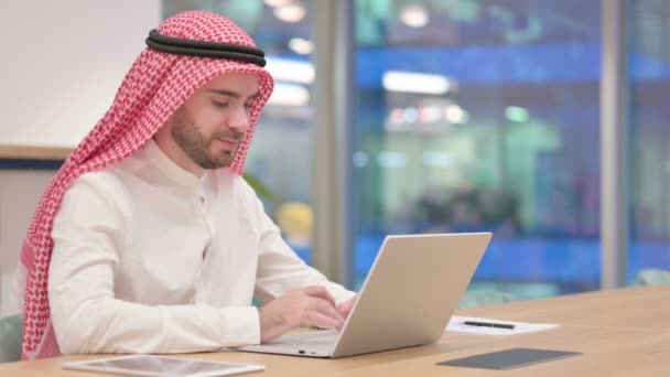 Empresario árabe serio con el ordenador portátil diciendo no con el dedo firmar — Vídeos de Stock