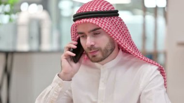 Neşeli Arap İş Adamı Ofiste Akıllı Telefonla Konuşuyor