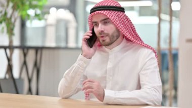 Neşeli Arap İş Adamı Ofiste Akıllı Telefonla Konuşuyor