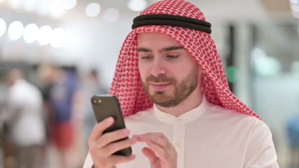 Porträt eines fröhlichen arabischen Geschäftsmannes, der auf dem Smartphone spricht — Stockvideo