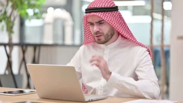 Empresario árabe estresado con computadora portátil que tiene dolor de cuello en la oficina — Vídeos de Stock