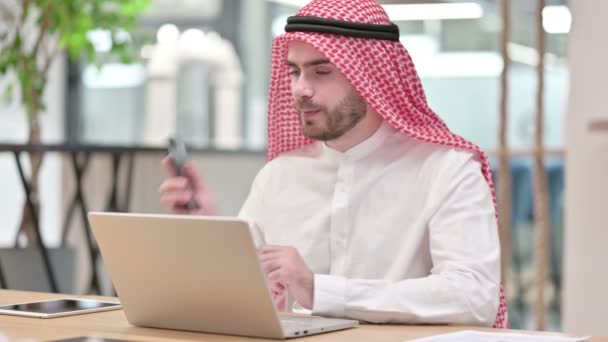 Arabische zakenman met laptop aan het praten op Smartphone in Office — Stockvideo