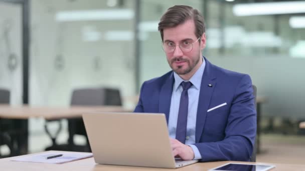 Jeune homme d'affaires sérieux avec ordinateur portable se sentant choqué — Video