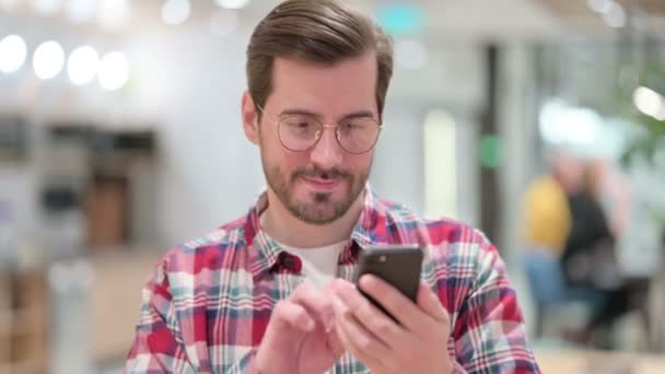 Porträt eines attraktiven männlichen Designers mit Smartphone — Stockvideo