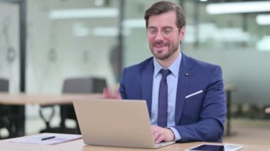 Neşeli Genç İş Adamı Laptoptan arıyor. 