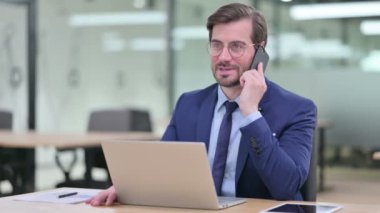 Bilgisayarlı Çalışkan Genç İş Adamı Akıllı Telefonla Konuşuyor 