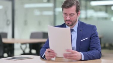 Odaklanmış Genç İşadamı Belgeleri Okuyor 