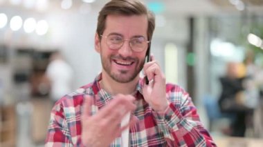 Akıllı telefondan konuşan neşeli genç adam.