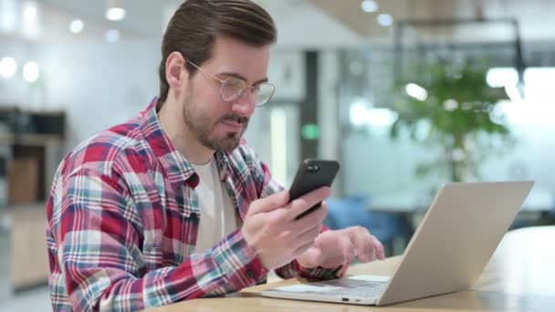 Designer Masculino Profissional usando Smartphone e Laptop — Vídeo de Stock