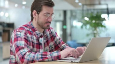 Dizüstü bilgisayarında baş ağrısı olan stresli erkek tasarımcı 