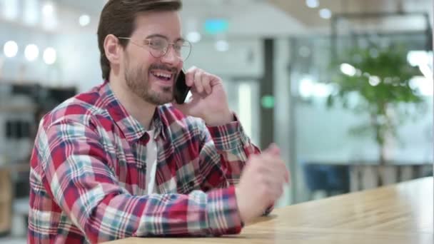 Amistoso diseñador masculino que habla en el teléfono inteligente — Vídeos de Stock